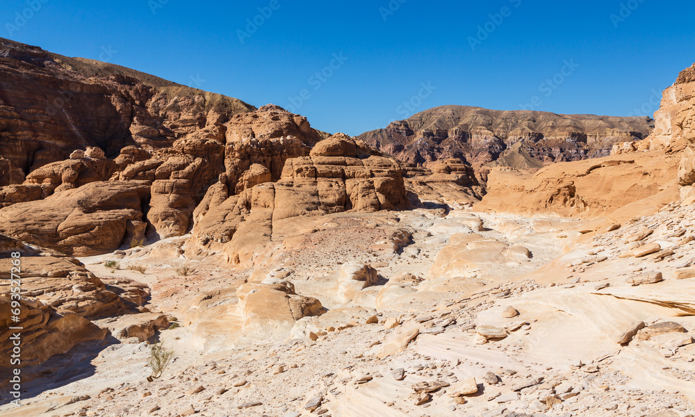 Sinai desert. Yellow and orange sandstone textured carved mountain, bright blue sky. Egyptian desert landscape. Sinai peninsula, Egypt