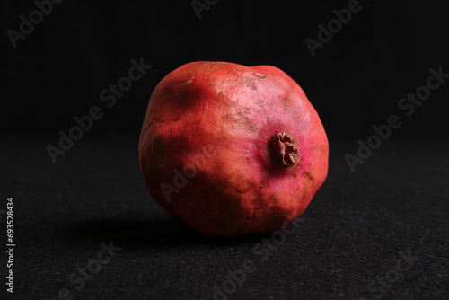 Melograno succoso rosso davanti a sfondo nero