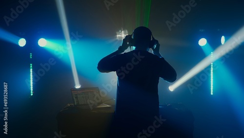Silhouette of a DJ at Club Event with Stage Lights