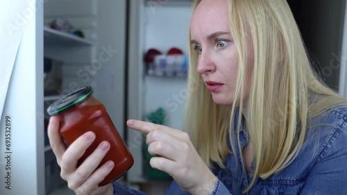 Woman reads instructions for food products at home. Checking labels on goods. Study of product compositions. Search Internet for descriptions of product gradients. Useful or harmful. Nutritionology