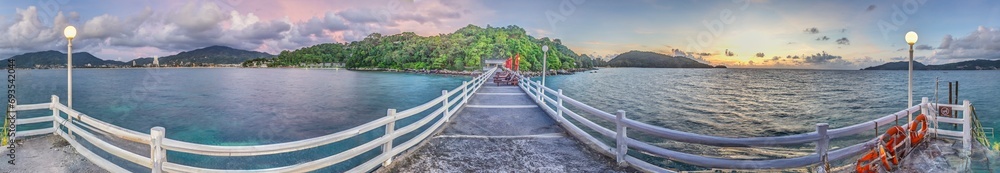 Panoramic picture over a jetty with wooden railing over the tropical sea near Patong on Phuket - obrazy, fototapety, plakaty 