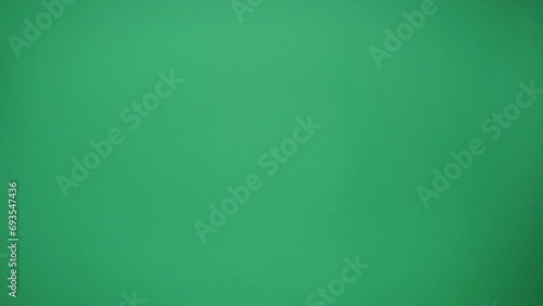 Man and woman exchange Christmas gifts in pink box on green background. Top view photo