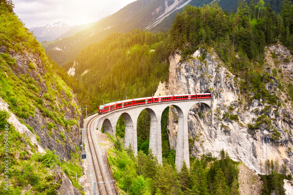 Swiss red train on viaduct in mountain, scenic ride - obrazy, fototapety, plakaty 