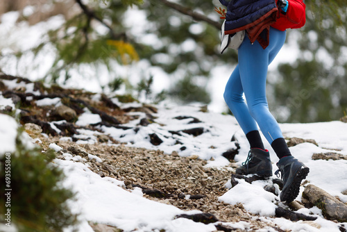 Colorful Dressed Woman Hiker Ascending to the top of a Mountain on a Snowy Mountain Trail in Autumn photo