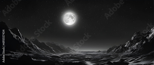 Full moon over a landscape with mountains in black and white.