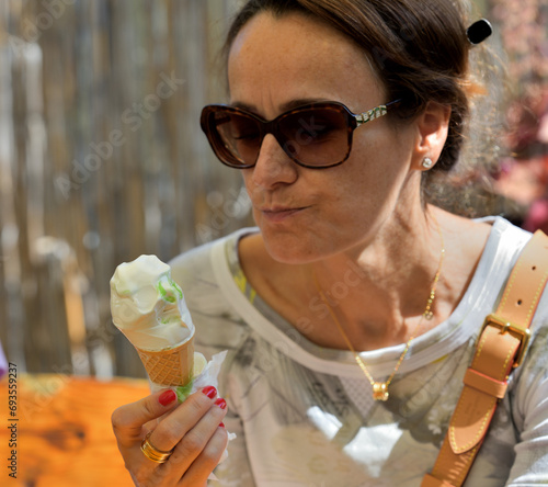 Obraz na płótnie Close-up of a woman's mouth licking sweet ice cream with her tongue w salonie