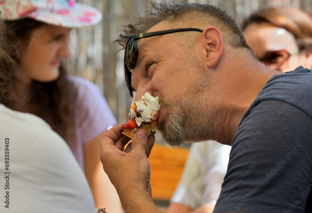People lick sweet ice cream on a trip in hot summer