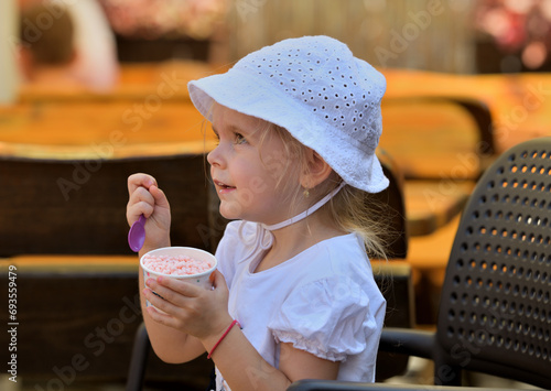Obraz na płótnie Portrait of a girl enjoying sweet ice cream in hot summer w salonie