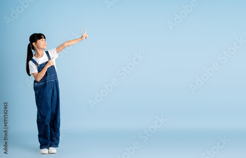 Full body image of an Asian girl posing on a blue background photo