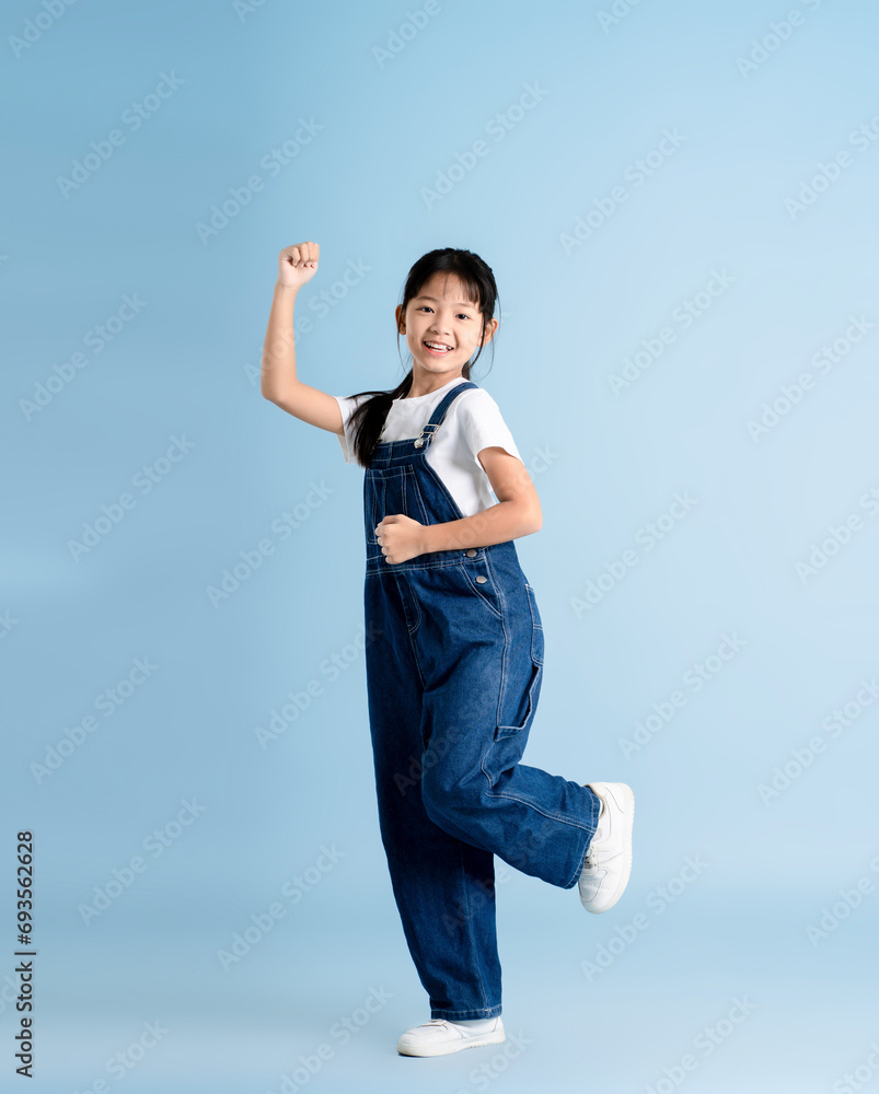 Full body image of an Asian girl posing on a blue background