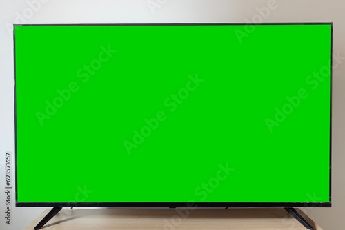 Green screen of a modern smart tv over a nordic wooden table style photo