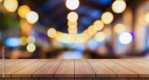 Empty wooden table top with lights bokeh on blur restaurant background