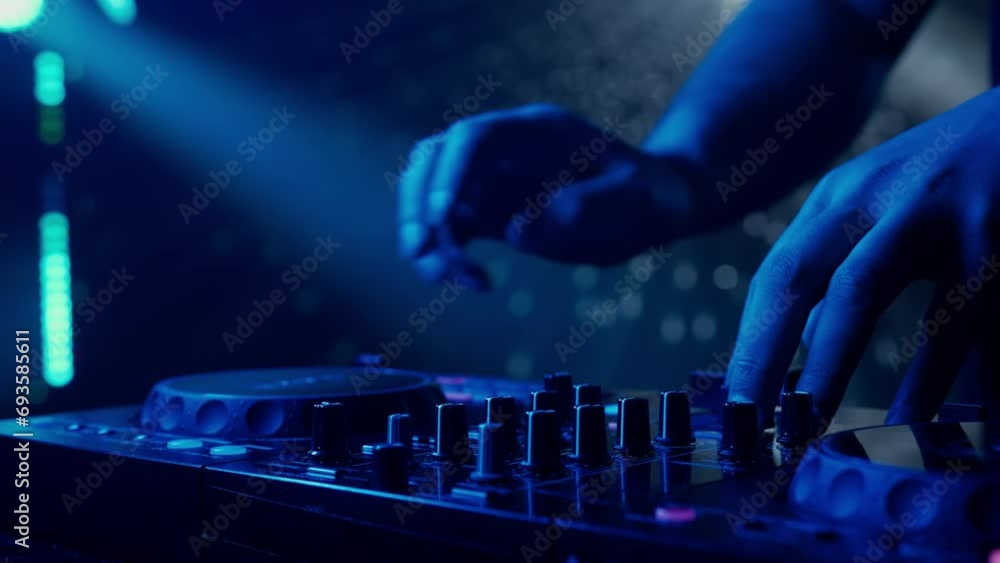 DJ's Hands Adjusting Sound Mixer Under Club Lights DJ's Hands Adjusting Sound Mixer Under Club Lights