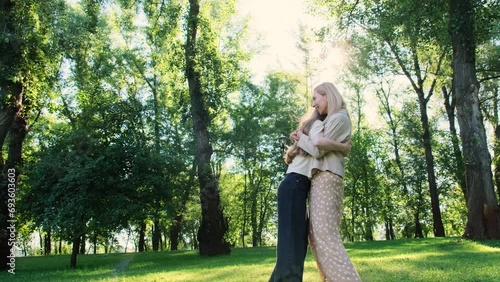 Joyous girl runs toward mother with arms extended expressing desire for heartfelt embrace. Mom happily reciprocates daughter affection photo