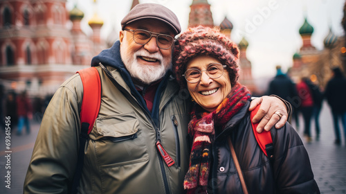 A happy, active senior tourists couple taking selfies against the background of the sights of Red Square, Moscow, Russia together having fun lifestyle. Active age concept