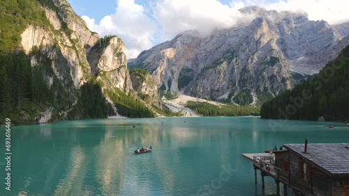 View over Lake Braies or Pragser Wildsee in the Dolomites, one of the most beautiful lakes in Italy. Boats in the middle of the lake surrounded by mountains. Travel and leisure. photo