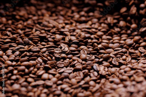 Macro fresh brown roasting coffee beans, warm light toning dark background