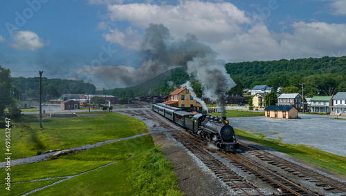 An Aerial View of a Narrow Gauge Steam Passenger Train, Leaving the Station for a Days Work, on a Sunny Summer Day