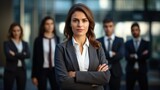 Young Confident businesswoman leader looking at camera standing outside office with teamwork. Female  corporate leader ceo executive manager posing for business portrait arms folded.