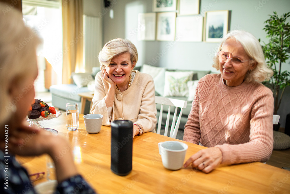 Senior women enjoying music on bluetooth speaker at home Senior women enjoying music on bluetooth speaker at home