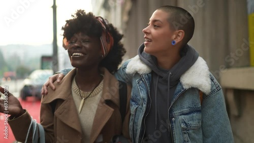 Happy young lesbian couple walking downtown