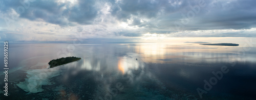 A serene sunrise illuminates the remote island of Koon near Seram, Indonesia. This scenic island's coral reefs, and the surrounding seas, support extraordinary marine biodiversity. photo