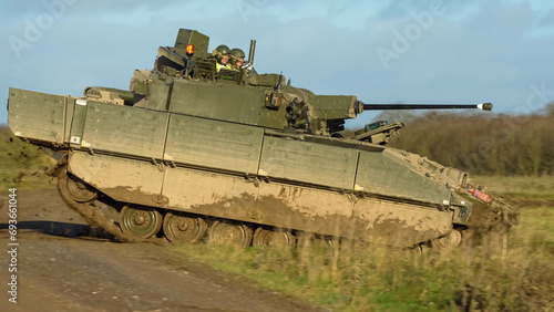 British army General Dynamics Ajax Reconnaissance and Strike armoured fighting vehicle (AFV), tank in action, crossing a track. Wilts UK