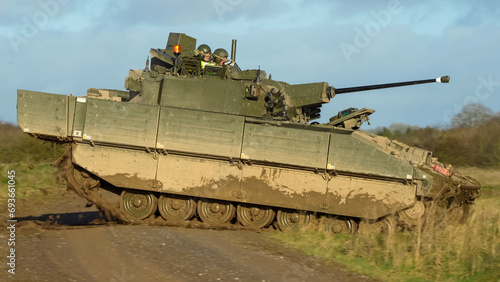 British army General Dynamics Ajax Reconnaissance and Strike armoured fighting vehicle (AFV), tank in action, crossing a track. Wilts UK
