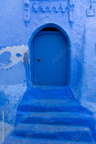 Old door of a house on a street painted blue in the medina of Chefchaouen, Morocco © Vicente Sargues