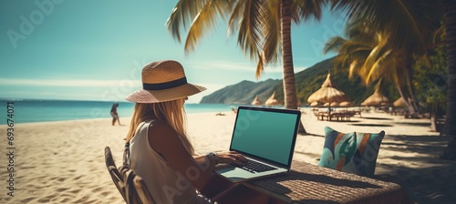 Young woman working on laptop computer by the beach  freelance work and travel concept
