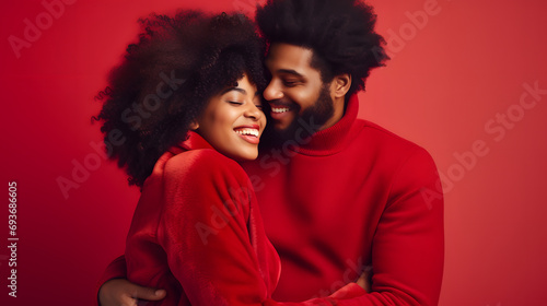 Portrait of a young black couple hugging, smiling in red clothes on a red background. A man and a woman in love are enjoying Valentine's Day. The concept of a romantic relationship for a photo shoot.