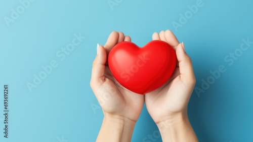 Hand holding a handmade red heart as a symbol of appreciation on blue background for International Nurses Day  celebrating healthcare heroes.