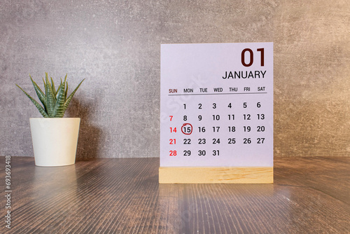 January 15 calendar date text on white wooden block with stationeries on wooden desk. Calendar date concept.