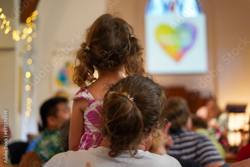 Mother and child from behind watching the carols church service at Christmas time.