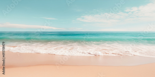 A pristine beach with turquoise waters, foamy waves, and a soft sandy shore under a blue sky with fluffy clouds. photo