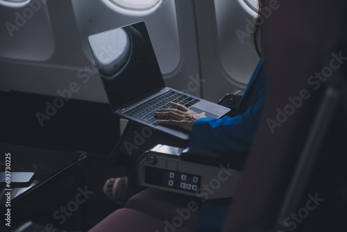 Using mobile and laptop, Thoughtful asian people female person onboard, airplane window, perfectly capture the anticipation and excitement of holiday travel. chinese, japanese people. © ARMMY PICCA