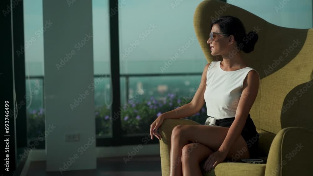 Young Asian business woman wear suit sit on couch chair smiling to camera in modern business lounge office. Gorgeous lady wearing sunglasses at Urban background. Pretty female happy luxury lounge room Young Asian business woman wear suit sit on couch chair smiling to camera in modern business lounge office. Gorgeous lady wearing sunglasses at Urban background. Pretty female happy luxury lounge room
