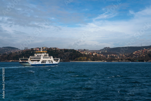 View of a city passenger ferry in the waters of the Bosphorus Strait against the background of the Asian part of Istanbul and the Beykoz district on a sunny day, Istanbul, Turkey