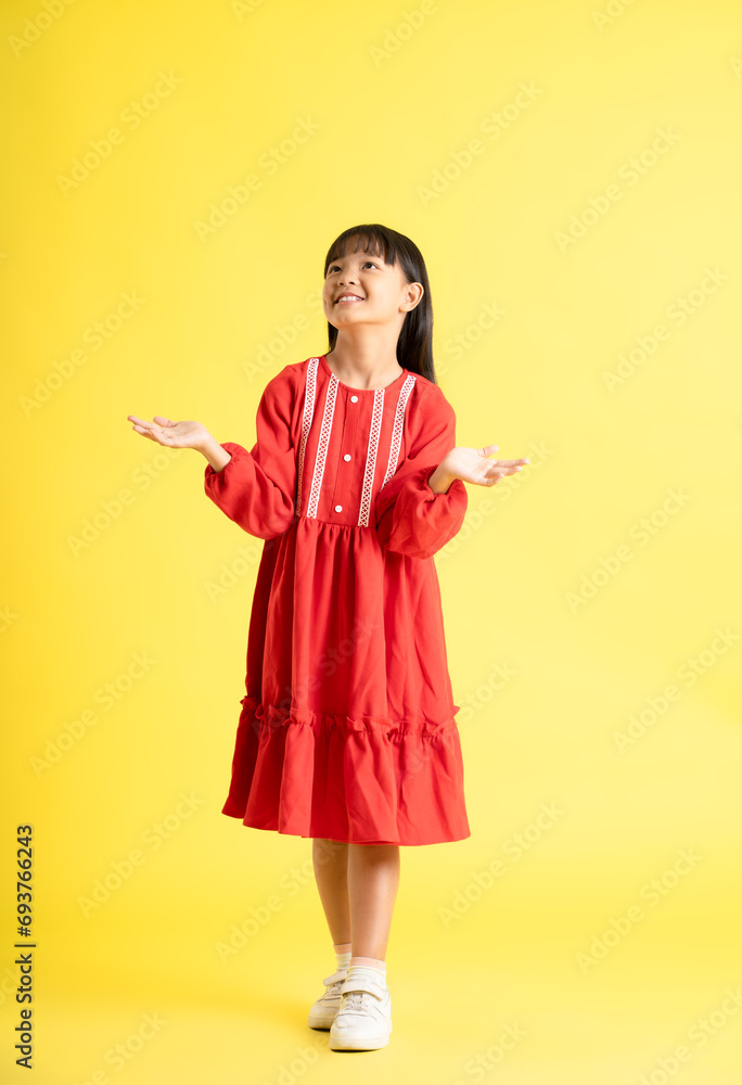 full body image of asian kid girl wearing dress and posing on yellow background
full body image of asian kid girl wearing dress and posing on yellow background