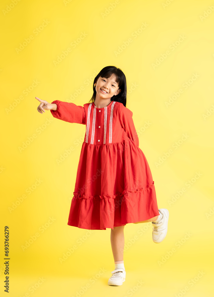 full body image of asian kid girl wearing dress and posing on yellow background
full body image of asian kid girl wearing dress and posing on yellow background