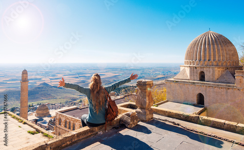 Traveler woman in Turkey,  female tourist sitting on rooftop enjoying panoramic view of Mardin city photo