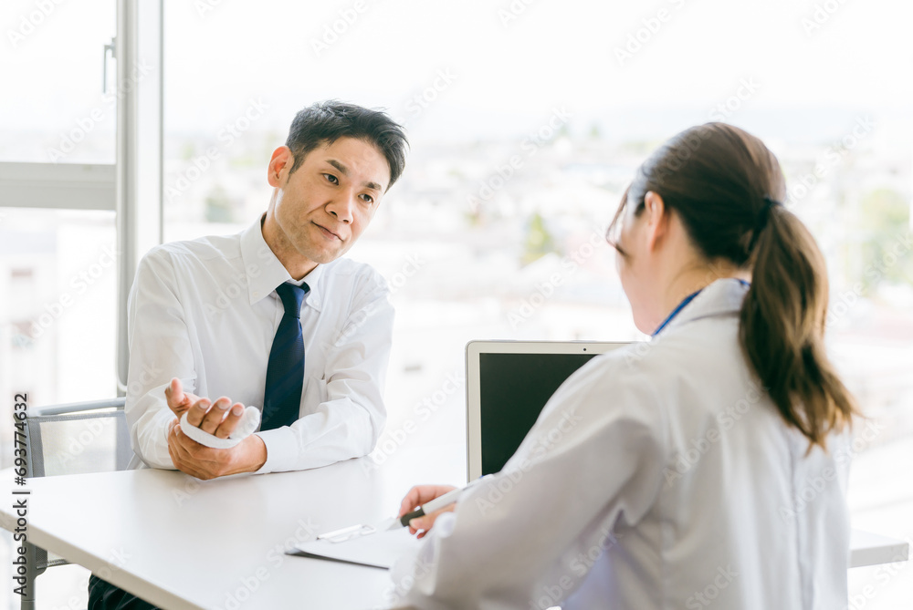 手の怪我で相談に来た患者と医者
手の怪我で相談に来た患者と医者