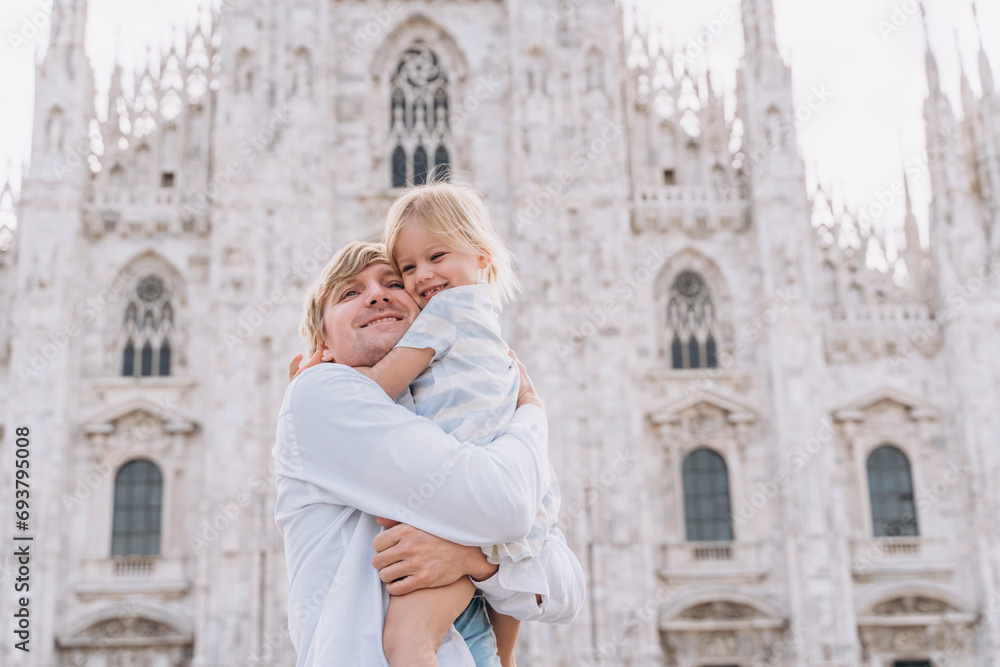 A man hugs his little daughter in front of the Duomo Milan