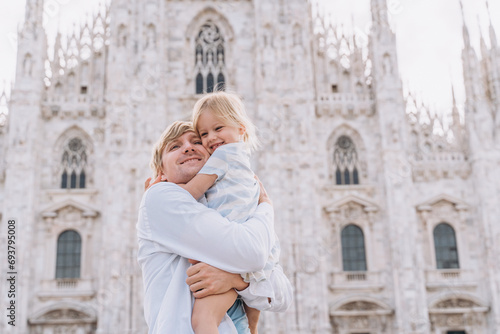 A man hugs his little daughter in front of the Duomo Milan photo
