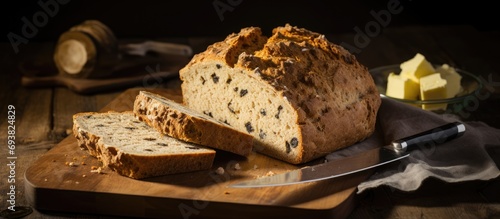Traditional Irish soda bread, sliced on a wooden board with a bread knife. photo