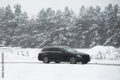 A car driving on a slippery highway in winter. Car on a snow-covered road with a lot of ice. The car has winter tyres. Winter time driving. Winter holidays with the family.