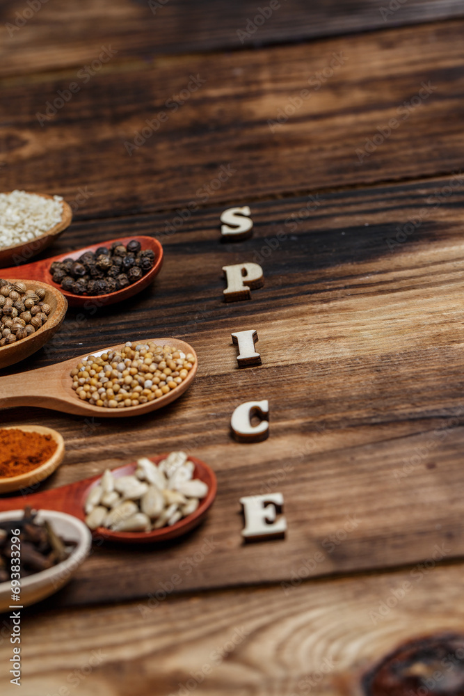 Many different spices in wooden spoons on a wooden background, background with spices, spices in spoons Many different spices in wooden spoons on a wooden background, background with spices, spices in spoons