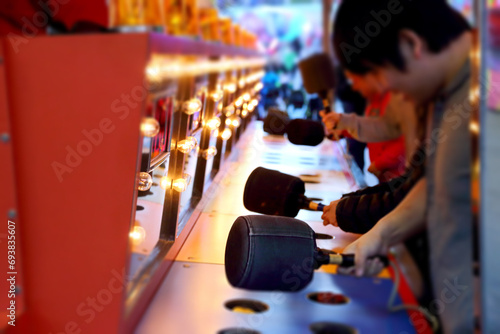 People playing whack game at carnival photo