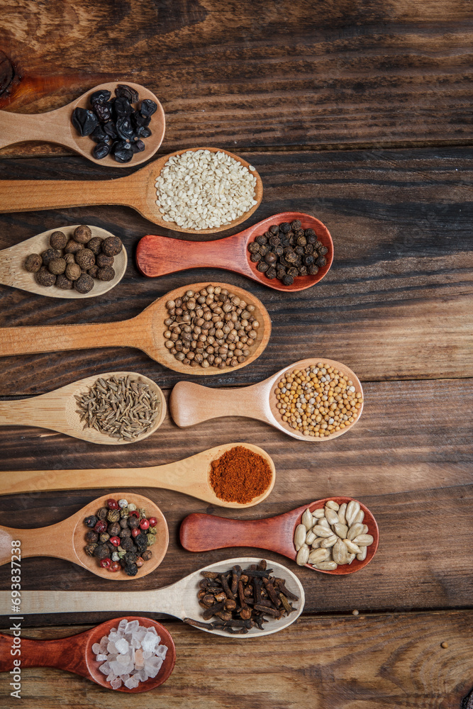 Many different spices in wooden spoons on a wooden background, background with spices, spices in spoons Many different spices in wooden spoons on a wooden background, background with spices, spices in spoons