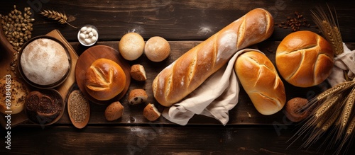 Sweet bread and rolls arranged on a table with baking tools, viewed from above, empty space available. photo